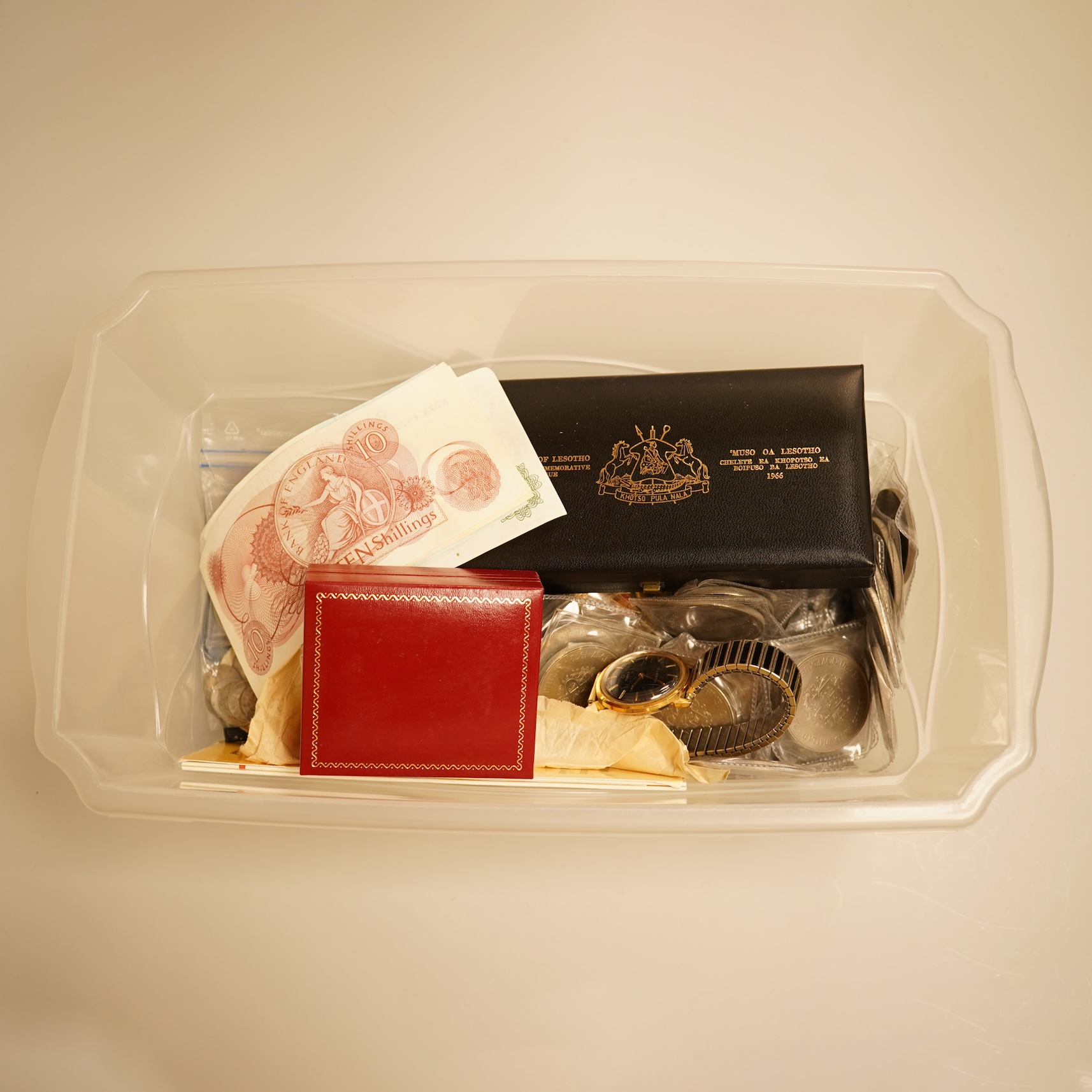 A collection of coins, notes and wrist watches